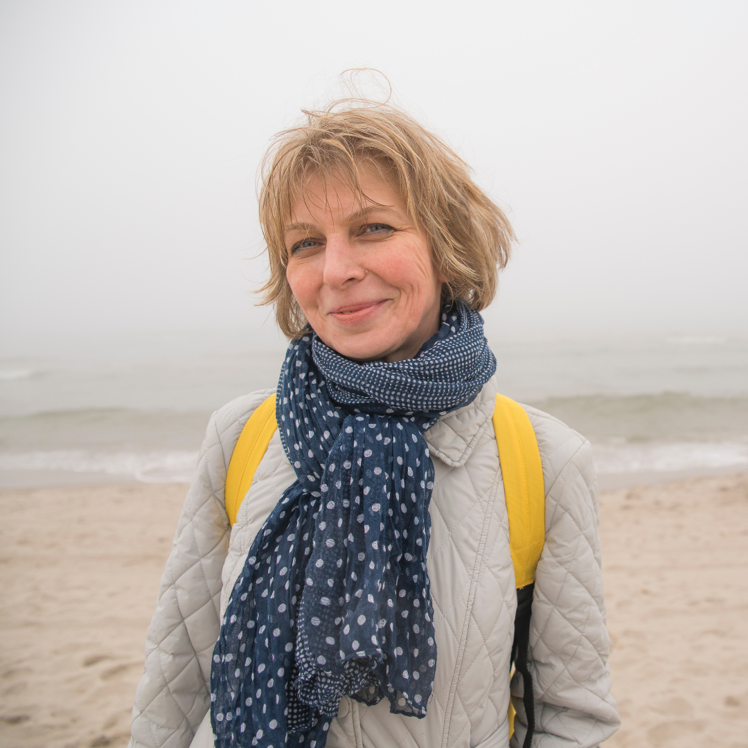 Kundin, namens Miriam, Ende 30, lachend am Strand. Sie hat eine 5 Sterne Bewertung für den ambulanten Pflegedienst abgegeben.